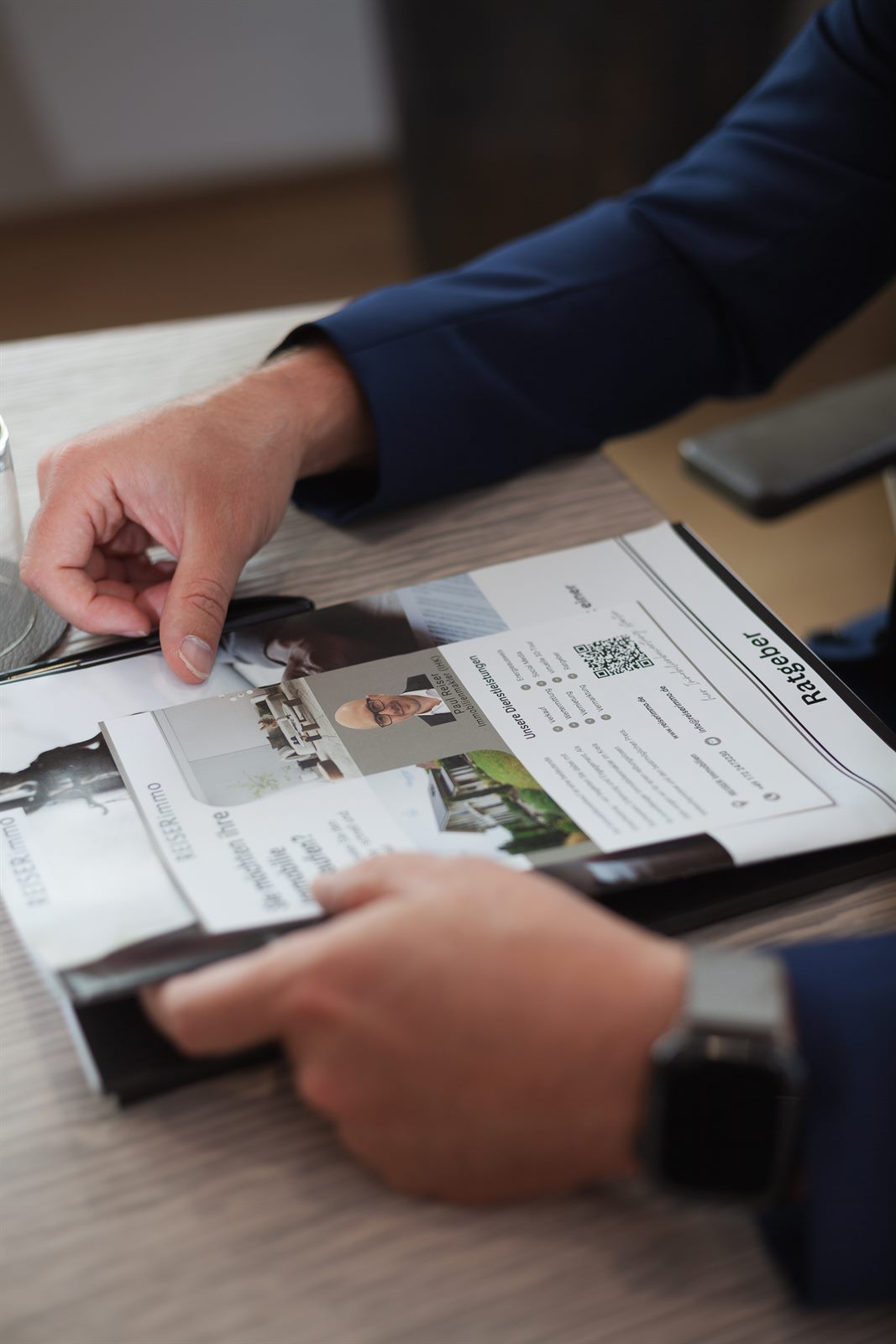 Exposé und Ratgeber von REISER Immobilien auf dem Schreibtisch